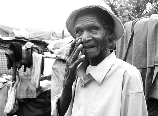 Dignified blind man living in a garbage slum.