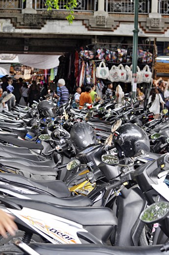 Motorbikes line the street outside of the markets in Ubud. The market place is set up to sell tourists souvenirs. This provides jobs, and monetary gain for the local people in Ubud.