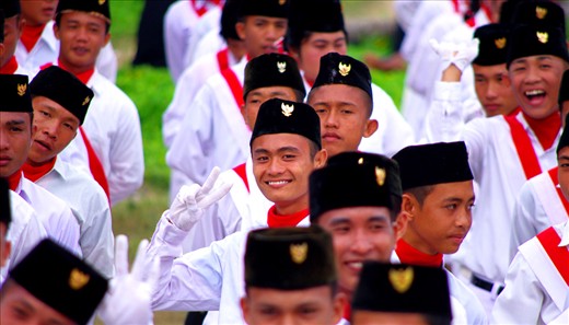 : Selemat Hari Merdeka. Happy Freedom Day.  Mischievous youths burst with pride at the Independence day ceremony, eager to raise the flag and sing for their Nation.
