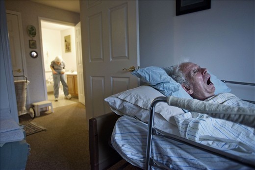 Roger lies in bed as Eleanor washes clothes in the bathroom. Eleanor didn't want to put Roger in a nursing home or be away from him. She felt it was important for her to take care of him to the best of her abilities.
