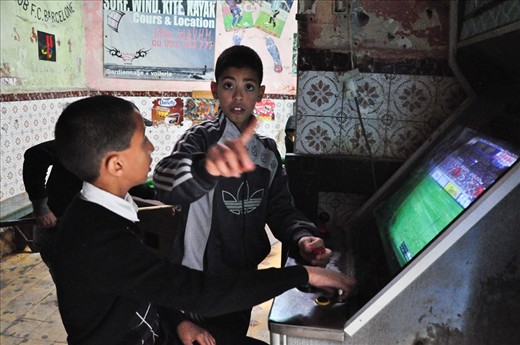 A little boy who doesn´t want to be photographed. Essaouira, December 2012 - As in Marrakech, as well in Essaouira we often met the children on the streets who went from school after which they was playing usually with a ball. In this city we found the place inside one of the many old buildings where were lot of kids „playing“ games on the games machines. It was interesting, and a little bit sad for me, they didn´t have a coins for the games, so in fact they didn´t play a real game, just watched the previews of the game. But still it is better as do the homeworks, or isn´t it? Kids are the same everywhere...