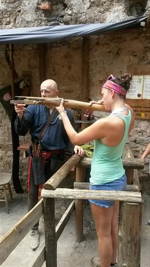 Karmen firing an old-style crossbow at Chojnik Castle