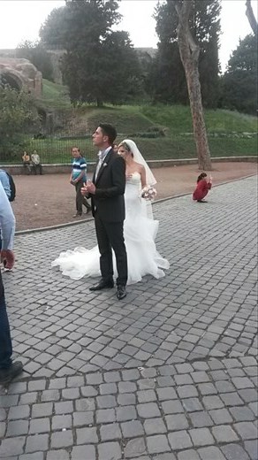 A couple taking wedding pictures in front of the Coliseum 