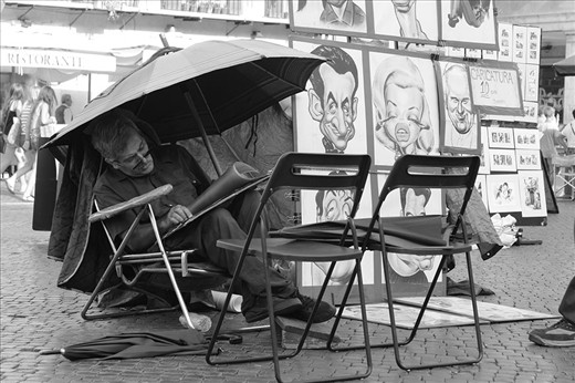 It takes someone with an immense amount of character to be able to draw a caricature. From his posture, to his small footrest, to his fascination for umbrellas, this man is truly an artist