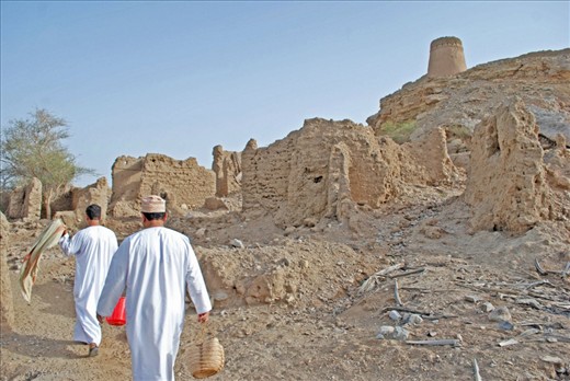 This photo is of my father and his younger brother, Salam walking back to the village compound after picking dates, as my father and his brothers did as young boys for their livelihood. They now only pick dates as a pass time when visiting the village. My father is carrying a plastic red bucket as my uncle has collected his dates in a traditional woven bag. 