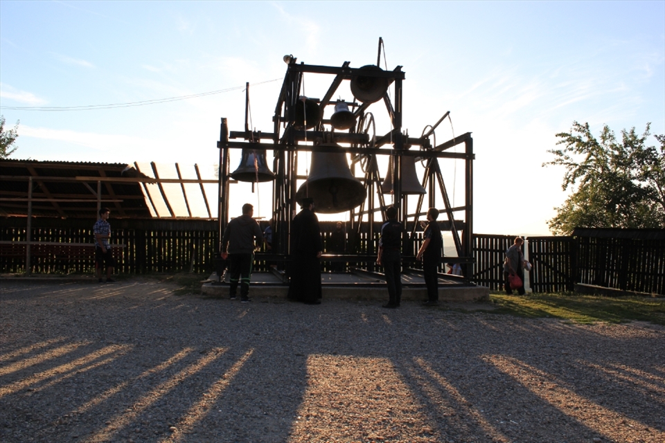 A priest from the monastery teaching some young boys how to ring the bells of the monastery.