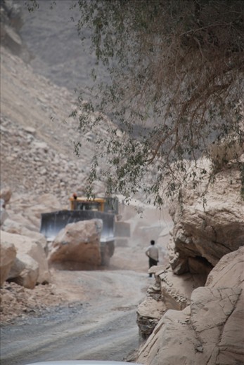 A bulldozer, watched by an expatriate labourer, moves a car-sized boulder at the entrance to Wadi Mistal during construction of a modern highway where Hadash is situated. In 3 years time access to the villages in this area will be much easier, prompting mixed feelings.