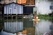 A boy uses a piece of a couch as a ship in a polluted river near an old landfill: by reality, Views[348]