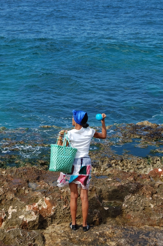 On the El Malecon Habanero in Havana, a woman faces the sea shaking a maraca - which amazingly parallels with Giraldalla, one of Havana's symbols, named after Carlos I's wife, who spent many evenings seeking her husbands return from the sea.