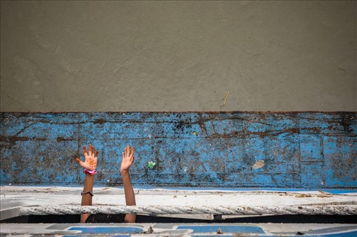 A young girl puts her arms out to feel the first drops of the monsoon 