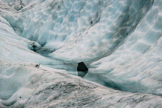 A lone black rock stood out vividly against the bright ice landscape 