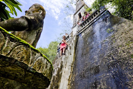 Children who go down the steep stairs of a temple of Buddha Park