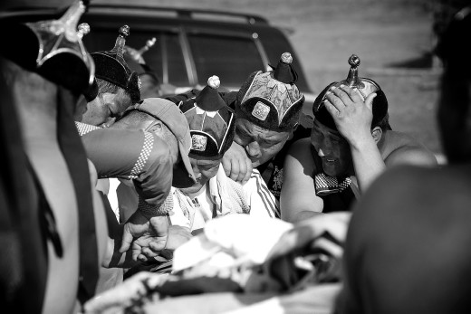 This experience was a complete stroke of luck. With scant details of what she was taking me to see, my Mongolian pen pal, Oyunaa, took me and my two mates to a training camp a few hours outside of the capital Ulaan Bataar. 
This image captured the coaches last pep talk to the best wrestlers from the strongest province before the national Naadam festival which was only a few days away. They were all happy, excited and silent. 

We later huddled around a small black and white TV, drank warm Korean beer and cheered them on from the middle of nowhere (Ikh-Uul).