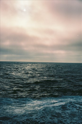 The Arctic ocean for as far as the eye can see, illuminated by a fog hazed sun