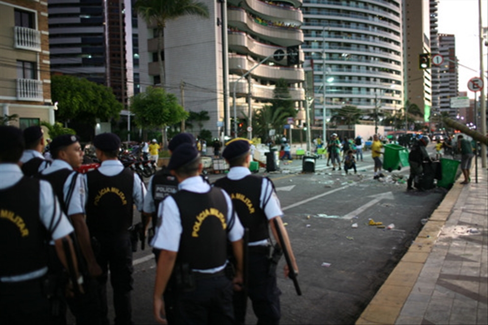 Protesters scatter from their makeshift barriers as police march towards them in a confrontation just outside the public viewing area where fans gathered to watch Brazil's opening match.  Rising costs and misspent funds on lavish stadiums sparked protests across the country.  Brazil will have spent an estimated $14 Billion USD staging the games.