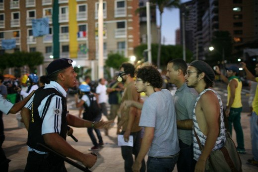 As the original protesters scatter, students voice their frustrations to the  baton-wielding police attempting to calm the crowd.  In the background, a loiterer prepares for the worse and sports a gas mask.  This protest was the final one of many throughout the day.