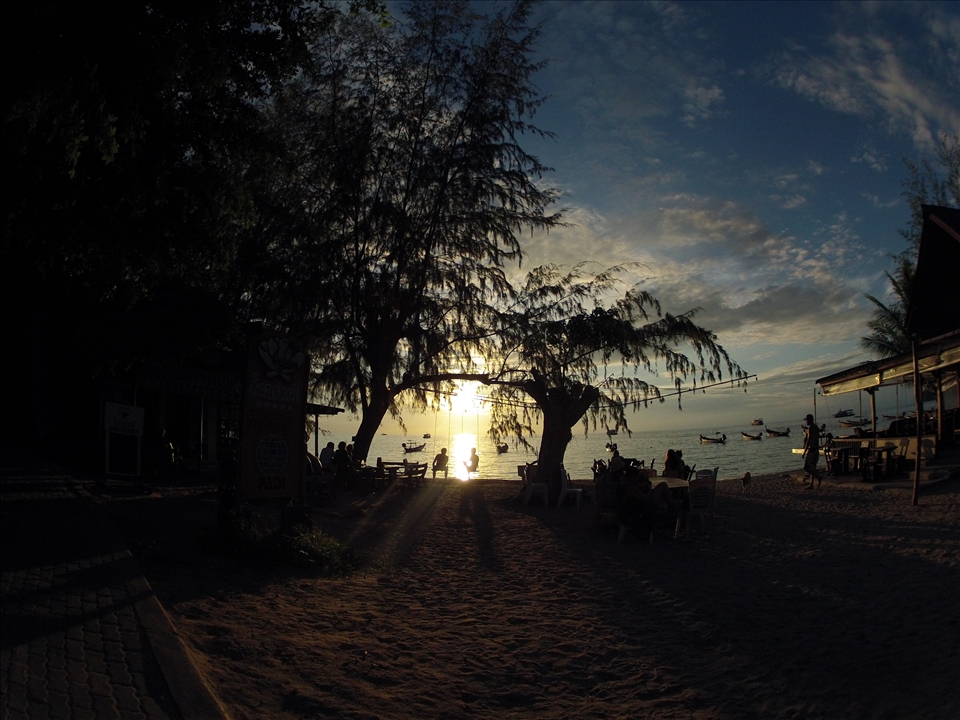 The land of smiles. Two Thai guys enjoy the sunset while swinging.  