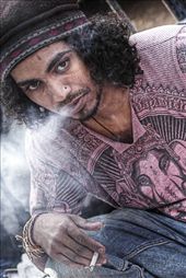 This picture tell me the story of a poor young guy who is jobless.  The attire he is wearing has Lord Ganesh on it. So I clicked this pic with his  expression of enjoying his smoke.: by ronit, Views[279]