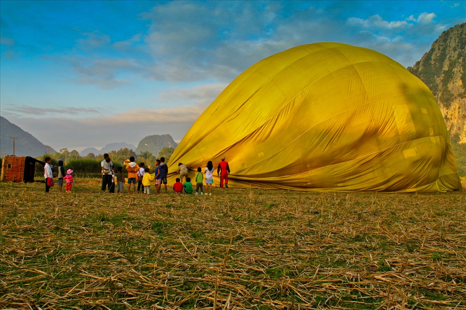 «Hot air baloon in Vang Vieng, Laos» 
Vang Vieng, Laos, December 2012. 
After a precious 60 minutes ride in a hot air ballon over Vang Vieng, the local people run to see the baloon landing, specially the kids.