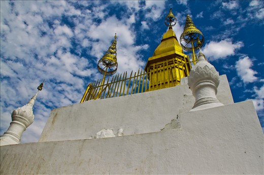 «Phu Si, Luang Prabang, Laos» 
Luang Prabang, Laos, December 2012. 
Phu Si is a 100m high hill in the centre of Luang Prabang. After climbing 328 stairs, we reach the summit of the hill, where we find Wat Chom Si, a Buddhist temple, which is one of the main attactions of this old town. The gilded stupa of Wat Chom Si seems to be looking at the sky.