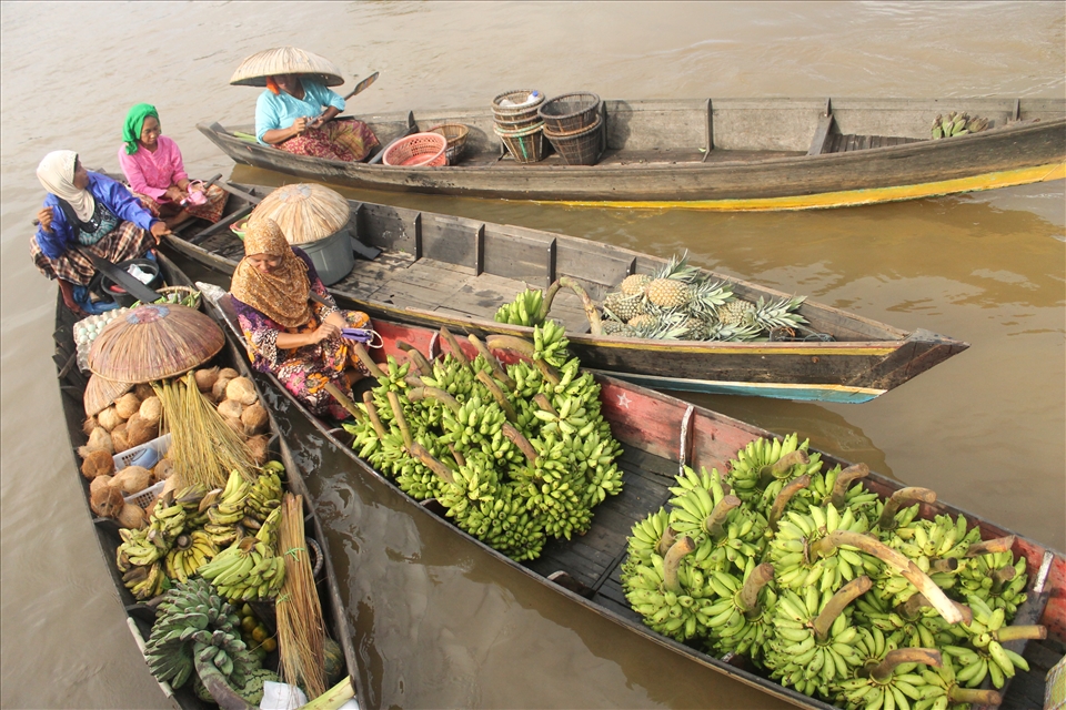 A bath of woman having a chit chat in floating market in their boat
