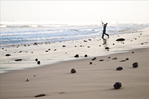 Ruquet Gelderbloem casts his line into the sea from the beach. Ruquet and his