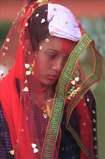 A bride on her wedding day at the  Shree Kedareshwor Mahadev Mani temple in Pokhara, Nepal.  She and her groom were escorted by a live band and a few guests.