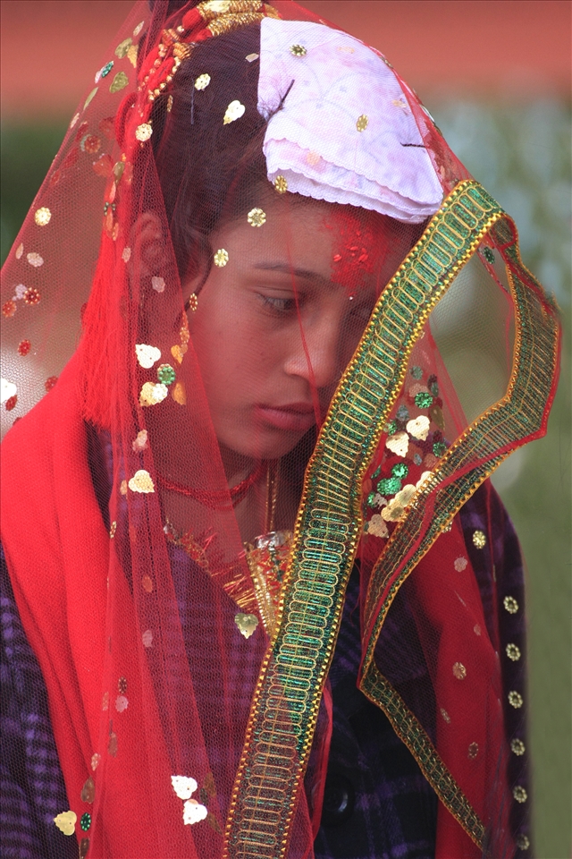 A bride on her wedding day at the  Shree Kedareshwor Mahadev Mani temple in Pokhara, Nepal.  She and her groom were escorted by a live band and a few guests.