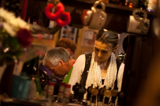 A reflection of the owners working away behind the small bar, surrounded by the various knick-knacks that hang off the pub's walls. I never did find out where the red fluffy handcuffs came from.