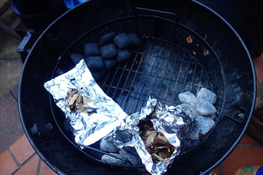 Setting up the smoker with a charcoal snake (for a slow burn and steady heat) and packets of wood chips for smoke.