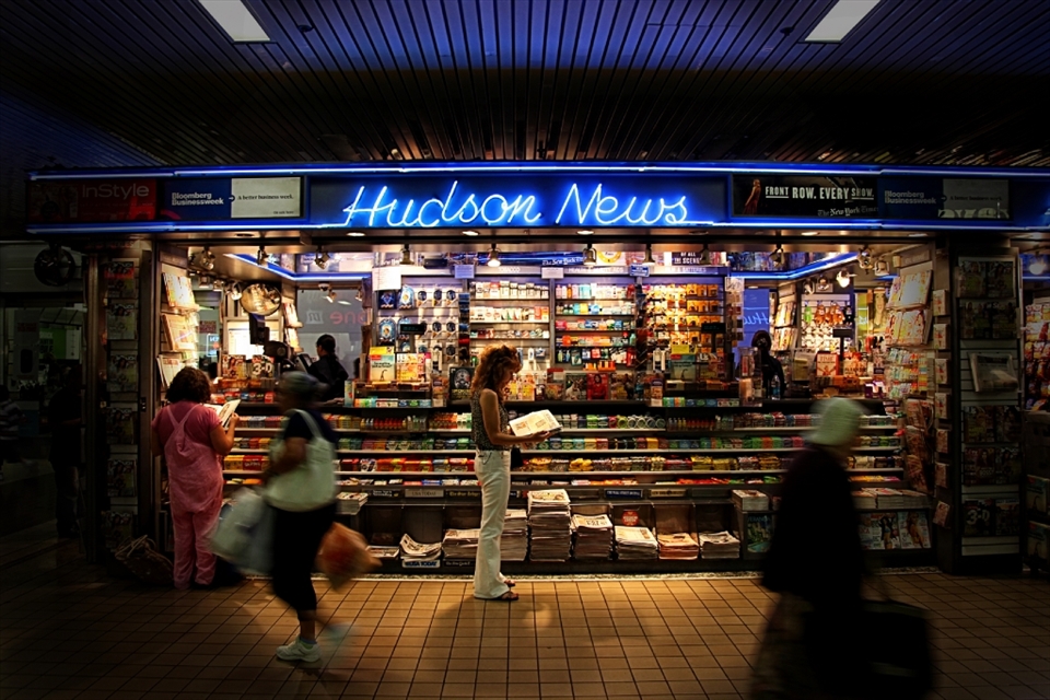 Hudson News Stand - A lady takes her time from the daily grind to catch the daily news/events.
