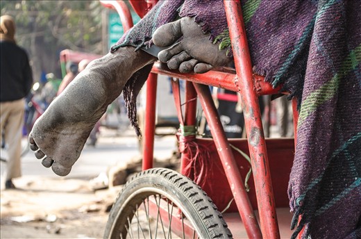 This picture was taken on the streets of Chandni Chowk market, is one of the oldest and busiest markets in Old Delhi. Cycle rickshaw drivers who does not have home / shelters use to sleep on their rickshaw (also known as pedicab) on the middle of the road.