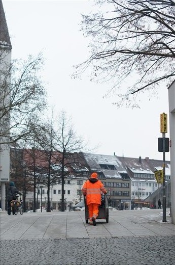 Council worker stands out from the grey tones of winter in the city