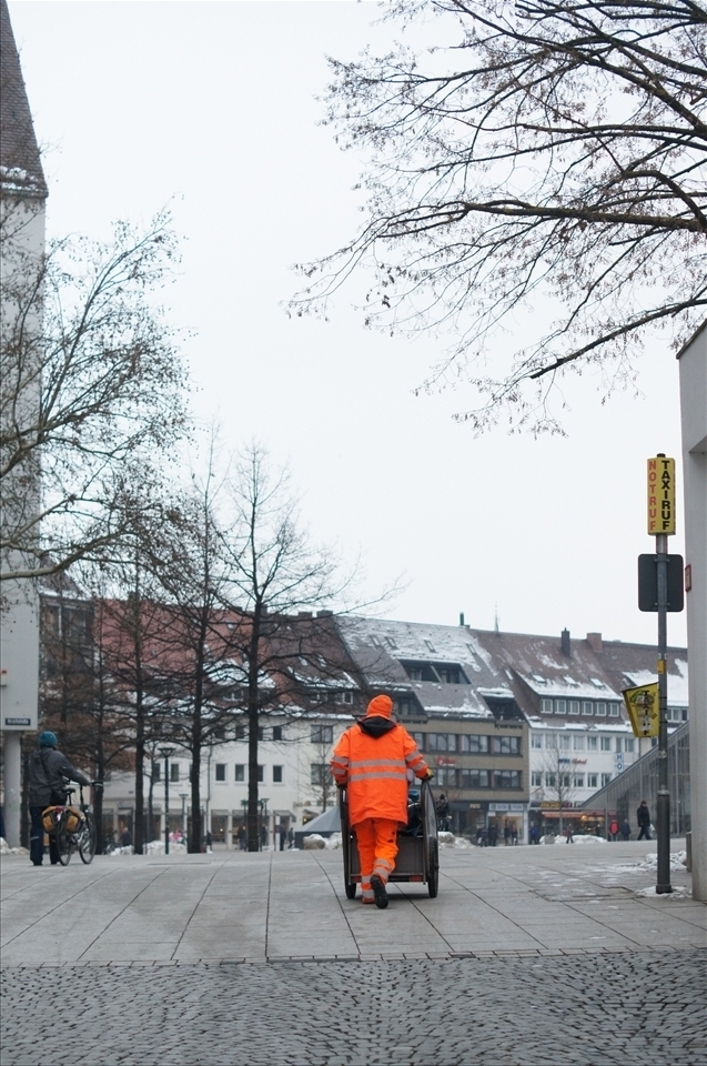 Council worker stands out from the grey tones of winter in the city