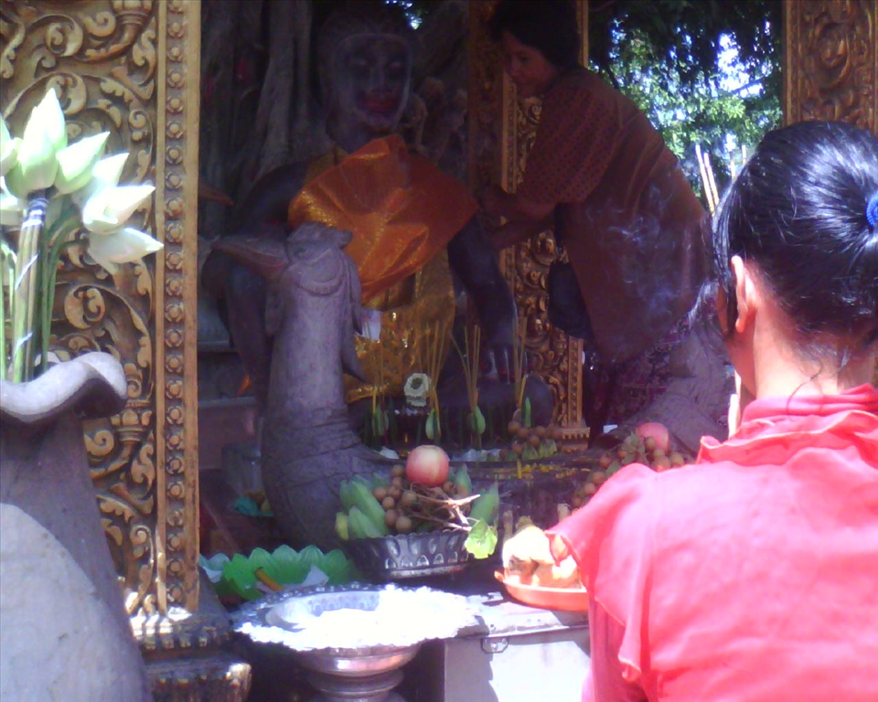 Such a devotion on a Buddha statue in the town of Siem Reap, Cambodia. 