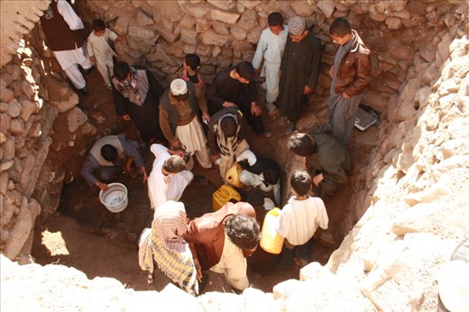 Group of youth are talking water from a natural well which comes from ground