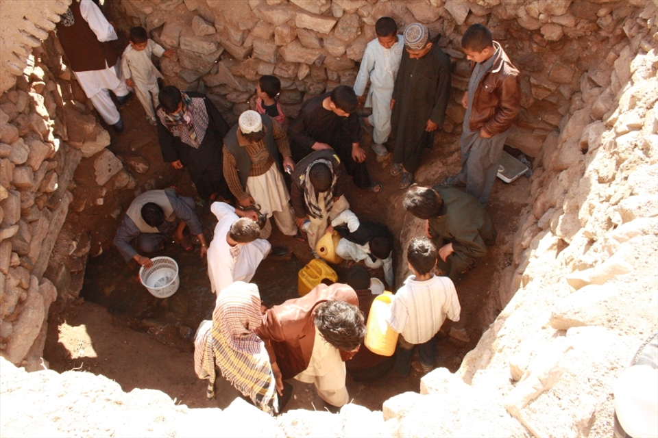 Group of youth are talking water from a natural well which comes from ground