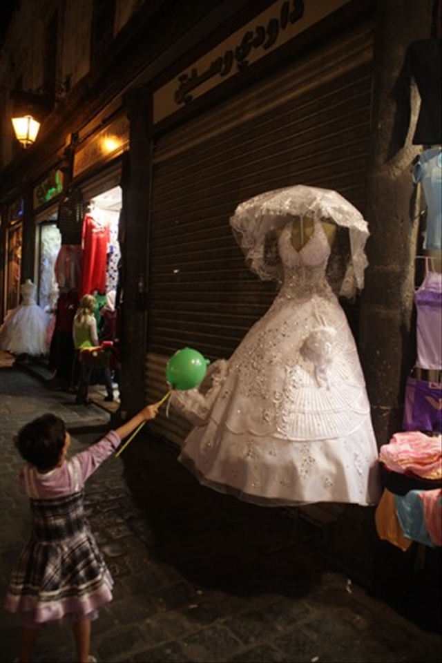 A girl looks in awe at the sight of a glittery wedding dress at Souk el Hamidiyeh