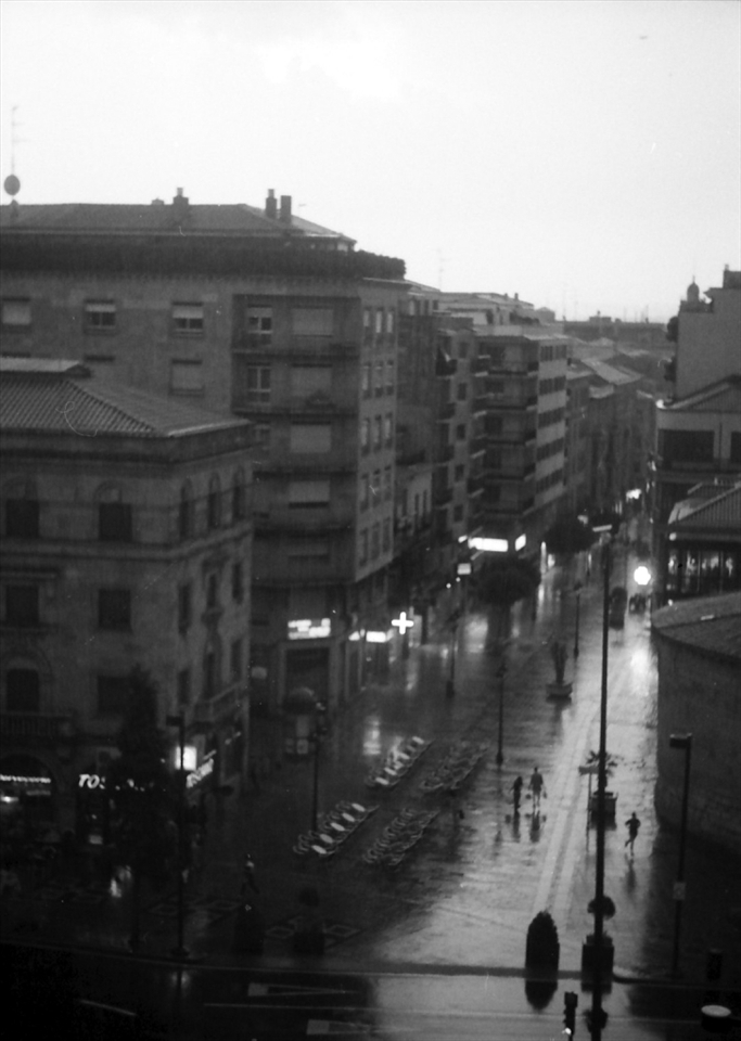 Afternoon, rain in Salamanca. One of the main streets of the city leading to Plaza Mayor. A boy rushes to his home.