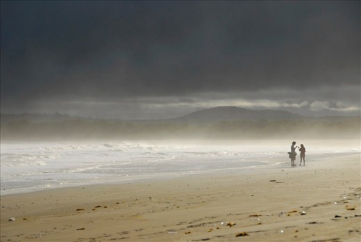 The jellyfish scattered beach is a popular hangout for the community of Puerto Villamil, the largest town on Isla Isabela.  Many people gather here daily to surf, explore the sea-life, and enjoy the laidback lifestyle.  In the background, Cerro Azul, an active volcano, peaks through the mist.