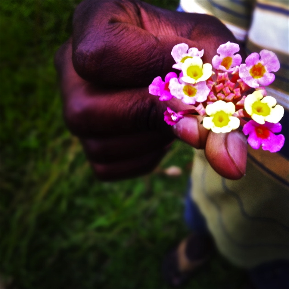 My host brother welcoming me to the family with lantana flowers!