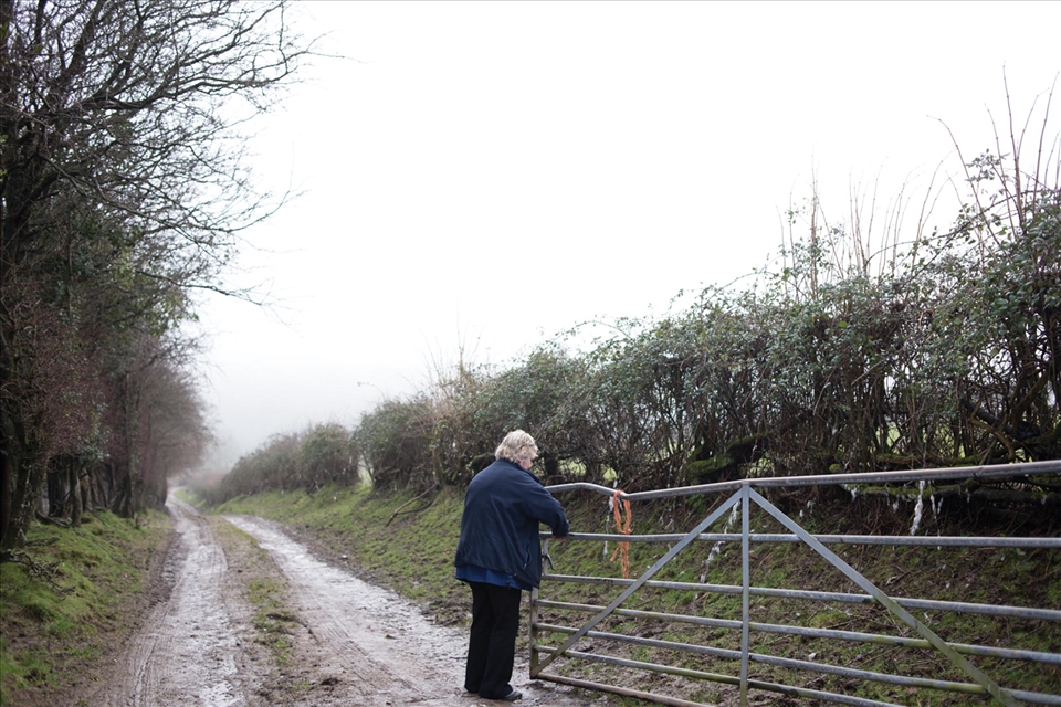 Jackie closes a gate to a farmhouse.