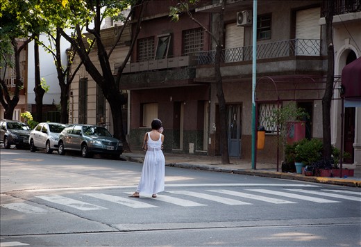 A woman in Buenos Aires waiting for a car to arrive and pick her up.