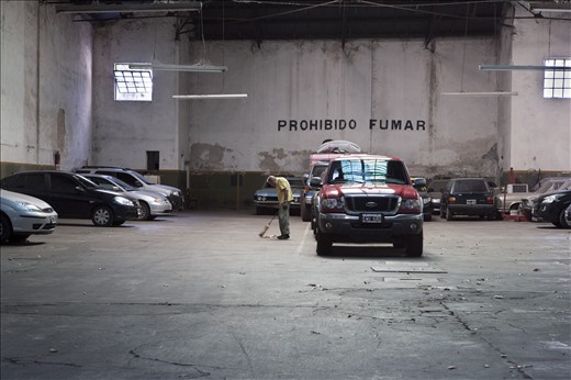 A man sweeping the floor of a parking garage as the day ends in Buenos Aires.