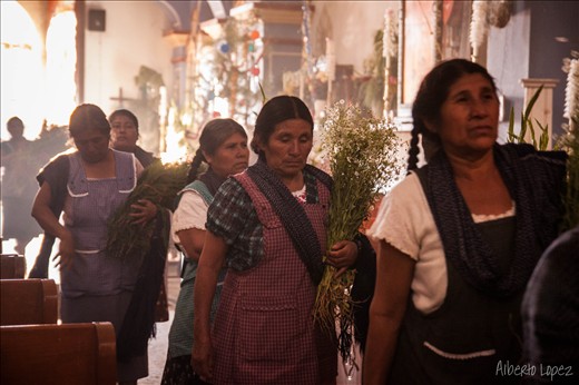 Locals visit the baby jesus on december 24th. All kinds of flowers are offered to decorate the church.