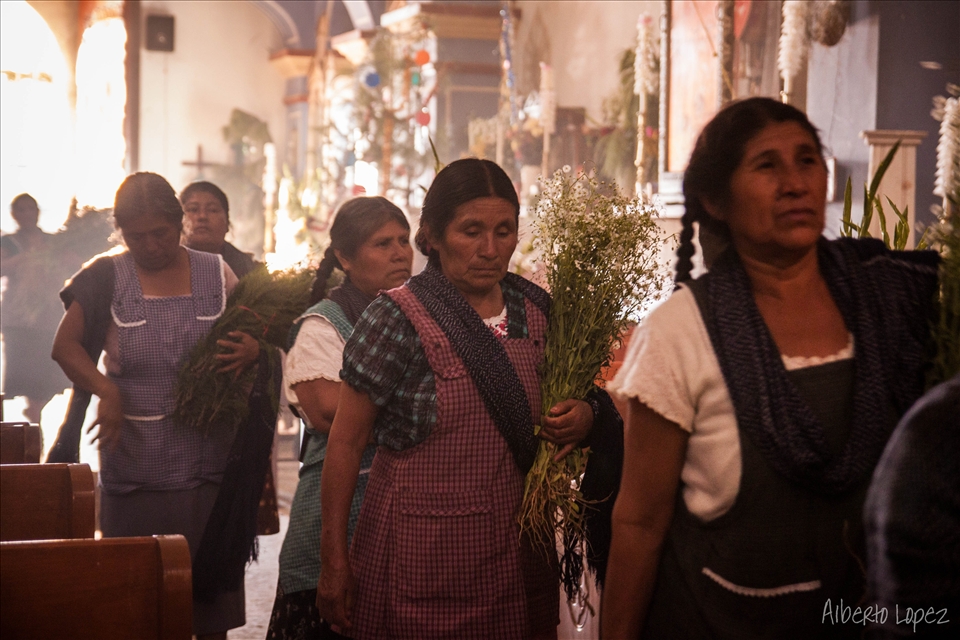 Locals visit the baby jesus on december 24th. All kinds of flowers are offered to decorate the church.