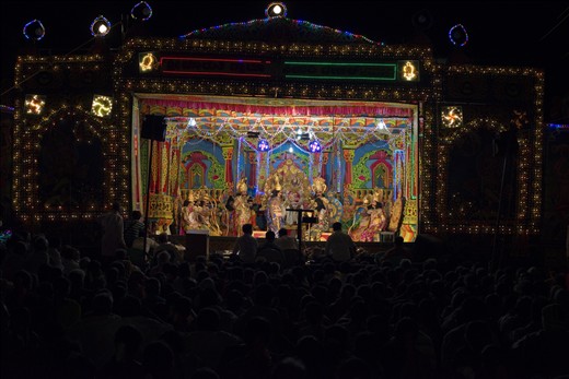 Drama set and the audience enjoying the show sitting on the ground, under the open sky