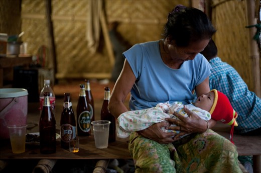 Grandma will take on the role of caring for her grandson during the day, enabling both mother and father to earn an income by working at the construction sites. (Lamphun, Thailand)