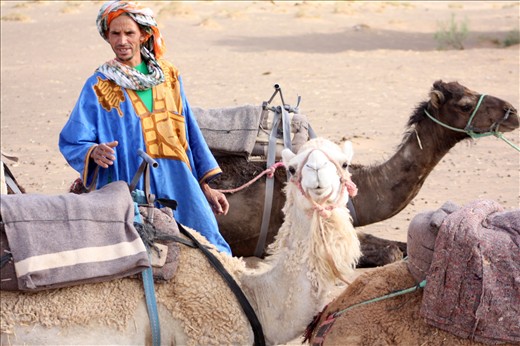 The journey into the Moroccan part of the Sahara begins just outside of Merzouga, and the Berber guides assist the travelers in mounting the tethered camels in groups of five.