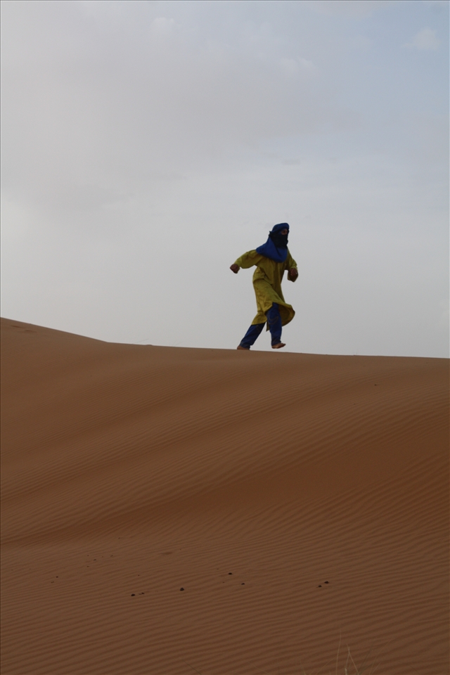 Despite the nearly 100 degree Fahrenheit heat, one guide ditches his soft leather shoes and runs up and down the dunes barefoot in his heavy garb. His laugh echoes on the wind as he runs, his sense of freedom clear.